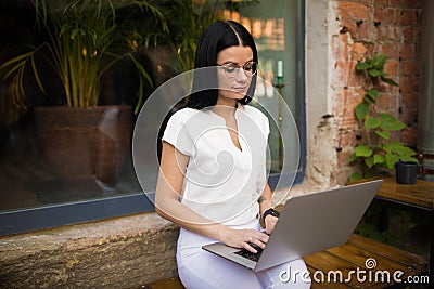 Young stylish hipster girl skilled freelance social media content writer using laptop computer for work Stock Photo