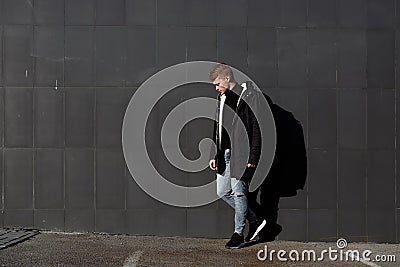 Young stylish redhead man in trendy outfit posing against urban background Stock Photo