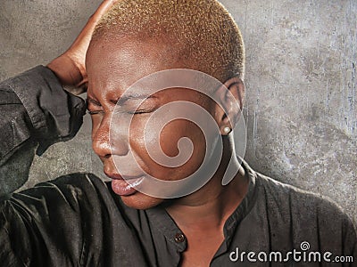 Young stylish sad and depressed afro american black woman crying in despair holding head with hands feeling miserable and desperat Stock Photo