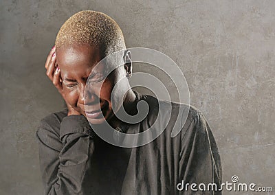 Young stylish sad and depressed afro american black woman crying in despair holding head with hands feeling miserable and desperat Stock Photo