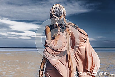 young stylish woman with fashionable boho accessories on the beach windy time Stock Photo