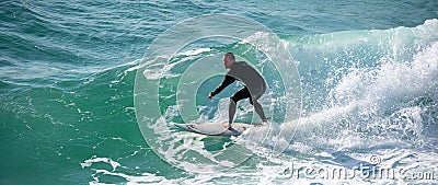 Young surfer enjoys the waves confronting the surf by surfing the rougher waters after a morning rain storm Editorial Stock Photo