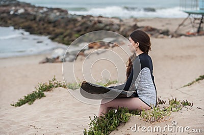 Young surfer girl overlooking beach. Stock Photo