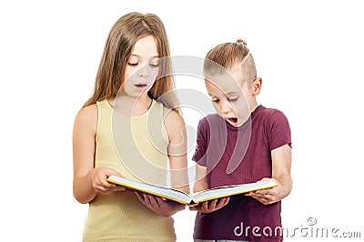 Young surprised cute girl and boy are looking at the yellow book Stock Photo
