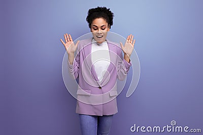 young surprised office woman dressed in a jacket looks down and raised her hands Stock Photo