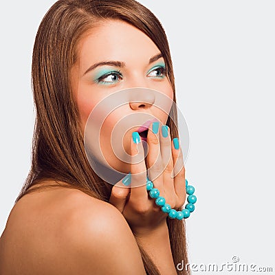 Young surprised woman holding a turquoise bracelet with bright m Stock Photo