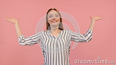 Young surprised woman with outstretched hands isolated on pink background. Unexpected guest visiting Stock Photo