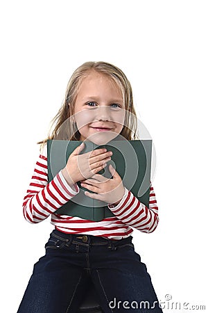 Young sweet little 6 or 7 years old with blond hair girl holding book smiling happy Stock Photo