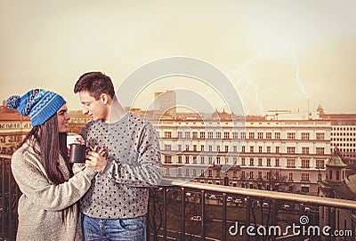 Young sweet romantic couple drinking coffee standing on terrace Stock Photo