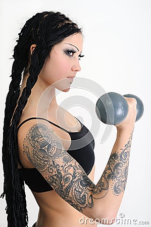 young tattooed woman with old dumbbells Stock Photo