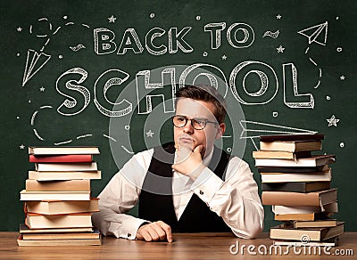 A young teacher in glasses sitting at classroom Stock Photo