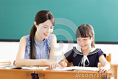 Young Teacher helping child with writing lesson Stock Photo