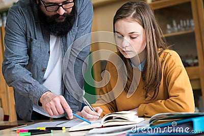 Young teacher helping his student in chemistry class. Education, Tutoring concept. Stock Photo