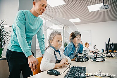 young teacher helping his teen students with diy robot on stem Stock Photo