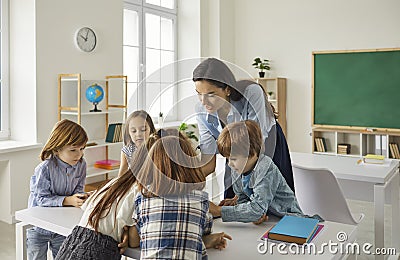 Young teacher teaching schoolchildren or preschooler group in classroom Stock Photo