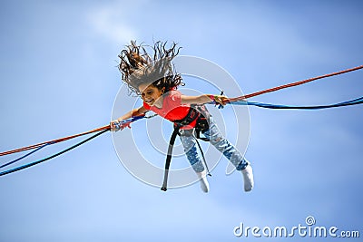 Young teen girl in bungee jumping trampoline Stock Photo
