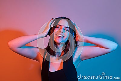 Young teen girl enjoy cool music party. Music, emotions concept. Carefree woman dances in rhythm of melody, closes eyes Stock Photo