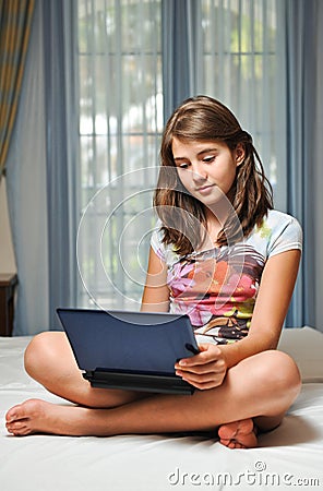 Young teen girl laying on her bed with notebook Stock Photo