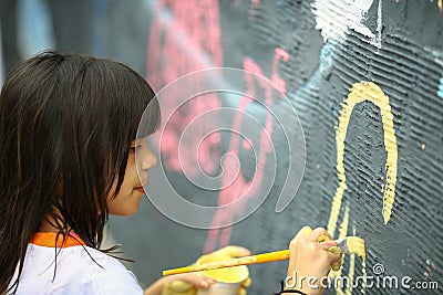 Young teen girl paints the wall Stock Photo