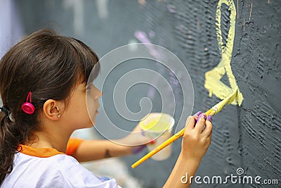 Young teen girl paints the wall Stock Photo