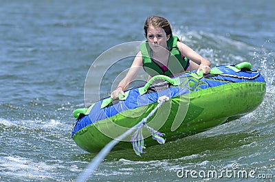 Young Teen Tubing Behind a Boat Stock Photo