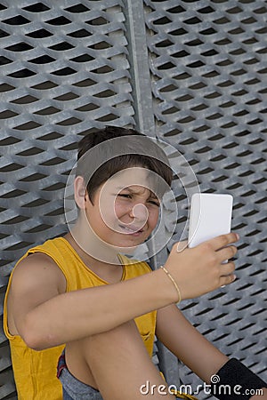 Young teen using his phone outdoors Stock Photo