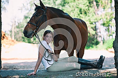 Young teenage cheerful girl equestrian hugging her favorite chestnut horse Stock Photo