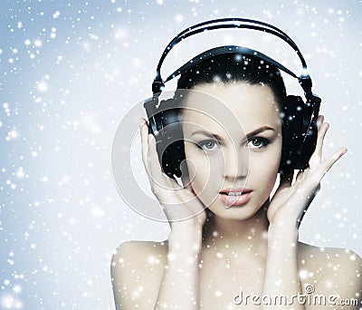 A young teenage girl listening to music in headphones on the snow Stock Photo