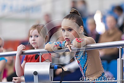 A young teenage girl prepares for performance, warming up and performs gymnastic elements at the competitions. Editorial Stock Photo