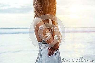 Young girl with silver tattoo and boho jewelry on sunset Stock Photo