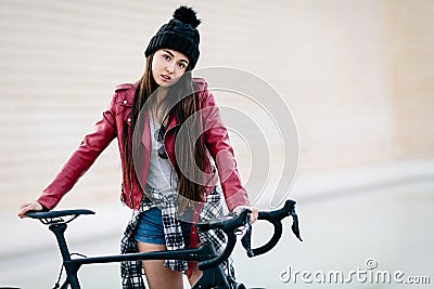 Young teenage girl waits on her bike with challenging look. School absenteeism concept Stock Photo