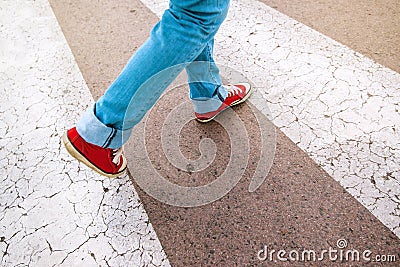 Young teenage person walking over pedestrian zebra crosswalk Stock Photo