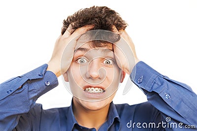Young teenager with astonished face on a white background. He was already tired of braces on his teeth and pimples on his face Stock Photo