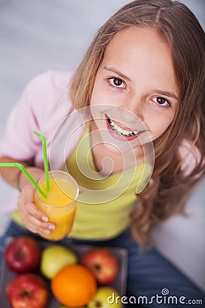 Young teenager girl with a broad smile hoilding a glass of juice Stock Photo