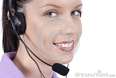 Young adult female telephonist with telephone headset, smiling, eyes looking at camera, close up Stock Photo