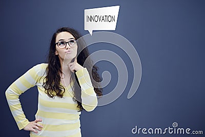 Young thinkful woman on blue gray background with finance graphs. Stock Photo