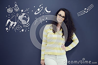 Young thinkful woman on blue gray background with universum icons. Stock Photo