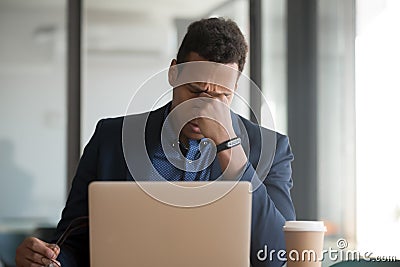 Young tired african american worker suffering from eyes pain Stock Photo
