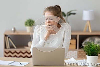 Young tired sleepy woman yawning working or studying with laptop Stock Photo