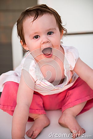 Young toddler girl on patio deck outside at sunset down at shore Stock Photo