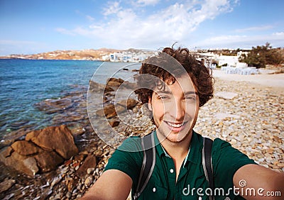 Young tourist taking selfie on Mykonos beach, Greece. Stock Photo