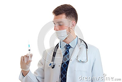 Young trained doctor with a mask on his face and a syringe in hand close-up Stock Photo