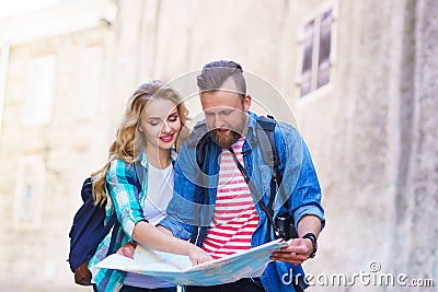 Young travelers with a tourist map. Man and woman having vacation. Backpackers, traveling and tourism concept. Stock Photo