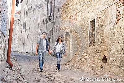 Young traveling couple having a walk on an old medieval street Stock Photo