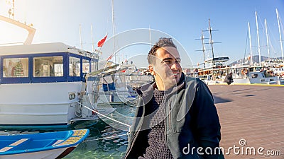 Young turkish tourist man smiling during sunset in Bodrum marina, Turkey. Sailing boats, sailor, and clear days Stock Photo