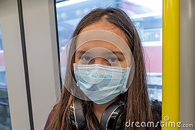 Young tween girl wearing surgical mask on subway Stock Photo