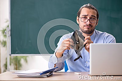 Young underpaid male teacher in the classroom Stock Photo
