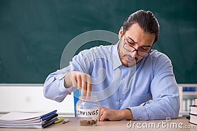 Young underpaid male teacher in the classroom Stock Photo