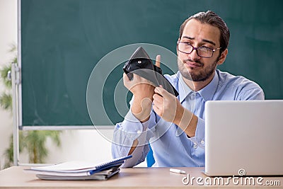 Young underpaid male teacher in the classroom Stock Photo