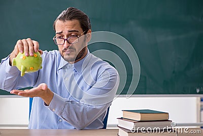 Young underpaid male teacher in the classroom Stock Photo